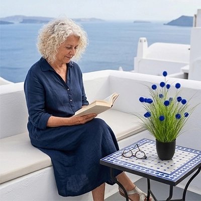 Une femme lit un livre dans son salon extérieur avec une Plante artificielle sur la table 