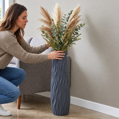 Une femme met des plantes dans le grand vase à côté du canapé
