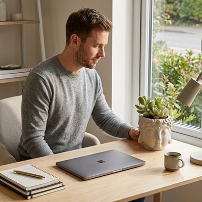 un homme met un Pot de fleuren Format Buddha  sur son bureau