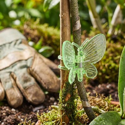 Support plante grimpante en forme de papillon qui tient une plante avec un baton