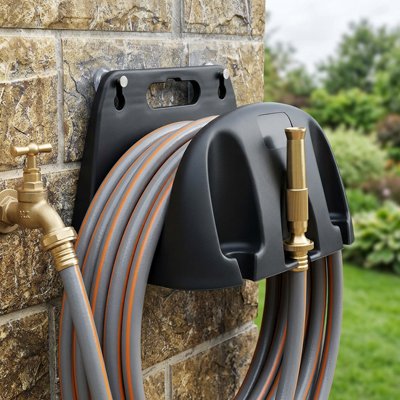 Support tuyau arrosage solidement installé sur un mur avec son tuyau 