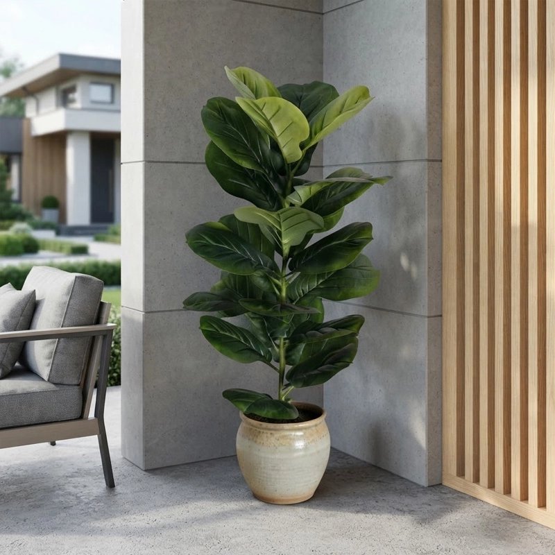 Un grand plante artificiel en pot décore élégamment le coin d'une terrasse moderne en béton et bois.