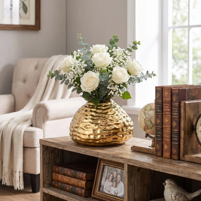 un vase avec des fleurs sur la bibliothèque du salon