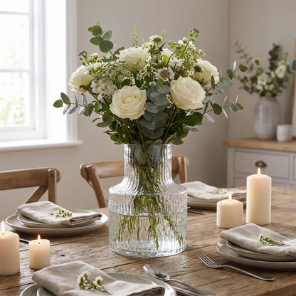 un vase en verre avec des fleurs décorent la table de la salle manger 